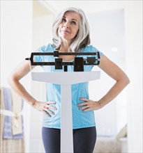 Caucasian woman shrugging on weight scale