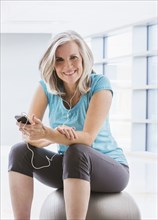 Smiling Caucasian woman in sportswear with mp3 player