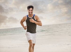 Caucasian man running on beach