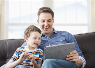 Caucasian father and son using tablet computer