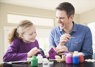 Caucasian father and daughter painting together