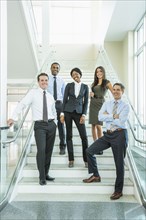 Business people smiling on office staircase