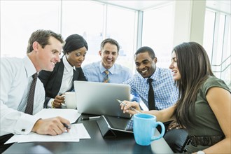 Business people using laptop computer in meeting