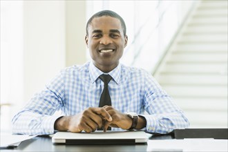 Black businessman smiling at desk in office
