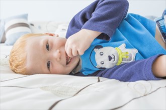 Caucasian boy smiling on bed