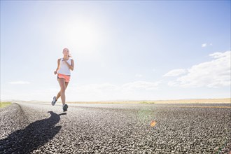 Caucasian woman running on remote road