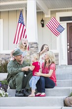 Caucasian soldier and family playing together on front stoop