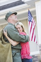 Returning Caucasian soldier hugging wife