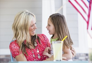 Caucasian mother and daughter laughing on porch