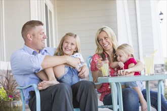 Caucasian family sitting on porch