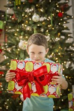 Caucasian boy holding Christmas gift