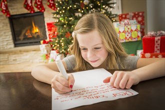 Caucasian girl writing to Santa at Christmas