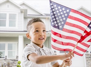 Mixed race boy waving American flag