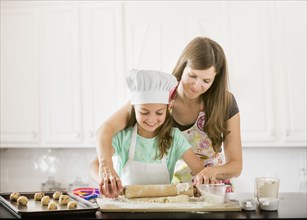 Caucasian mother and daughter baking in kitchen