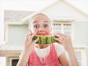 Caucasian girl eating watermelon outdoors