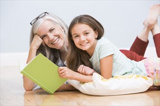 Caucasian grandmother and granddaughter reading book