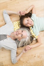 Caucasian grandmother and granddaughter laying on floor