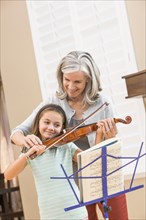 Caucasian woman giving student violin lessons
