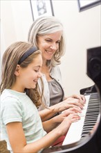 Caucasian woman giving student piano lessons