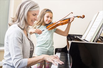 Caucasian grandmother and granddaughter playing music together