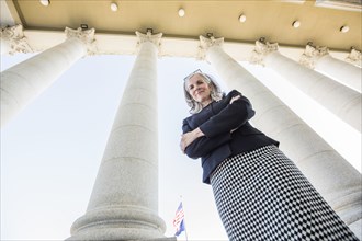Low angle view of Caucasian businesswoman standing under columns