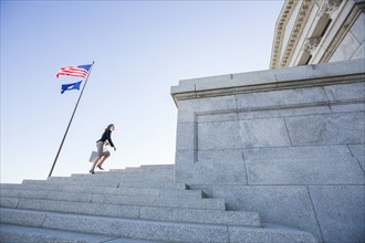 Caucasian businesswoman walking on courthouse steps
