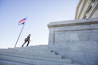 Mixed race businessman walking on courthouse steps