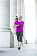 Caucasian woman jogging outside courthouse