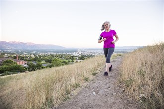 Caucasian woman running on hilltop