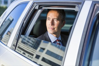 Mixed race businessman sitting in car