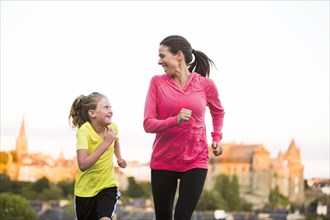 Caucasian mother and daughter jogging outdoors