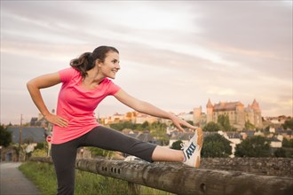 Caucasian woman stretching leg outdoors