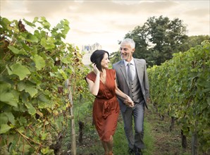 Caucasian couple walking in vineyard