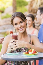 Woman drinking cocktail outdoors