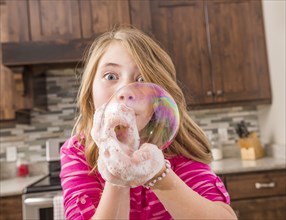 Caucasian girl blowing soap bubble