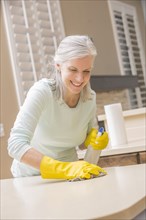 Caucasian woman cleaning kitchen countertop