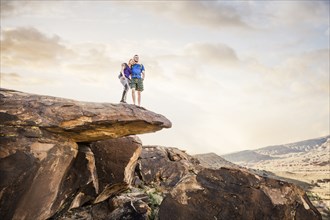 Caucasian couple on rock formation admiring landscape