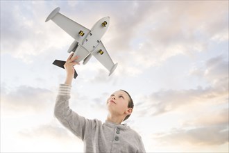 Caucasian boy flying toy airplane