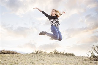 Caucasian teenage girl jumping for joy