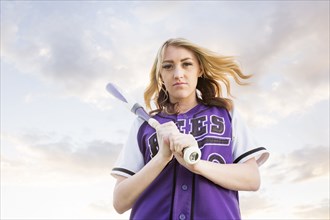 Caucasian teenage girl wearing softball uniform