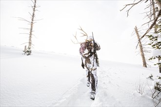 Caucasian woman hunting in forest carrying antlers