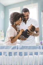 Black parents admiring baby son