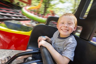 Caucasian boy smiling on amusement park ride