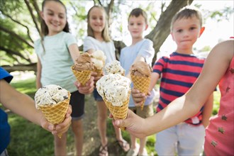 Caucasian boys and girls showing ice cream cones