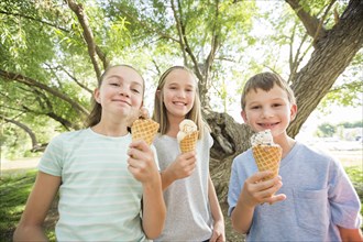 Caucasian boy and girls eating ice cream cones