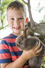 Caucasian boy holding rabbit