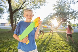 Caucasian boy posing with squirt guns