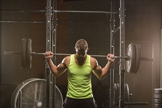 Caucasian man lifting barbell in gymnasium