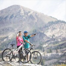 Caucasian couple standing with mountain bikes