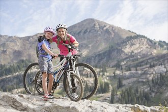 Caucasian grandmother and granddaughter posing with mountain bikes